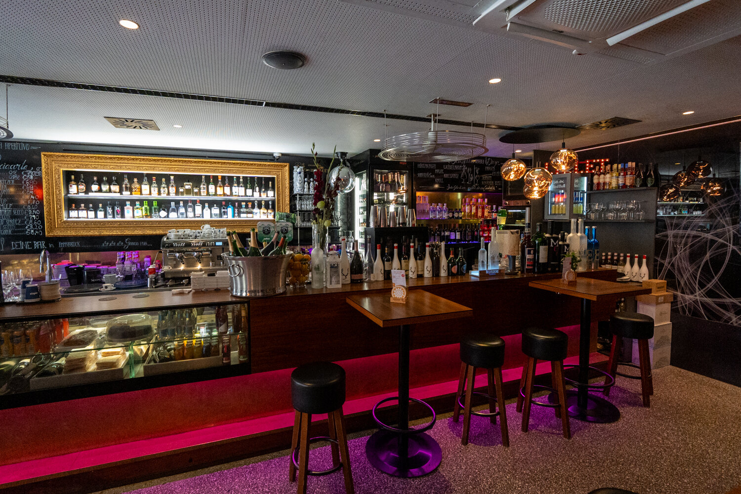 Lange Theke der Bar Centrale mit Weinkühlern, Espressomaschine und stimmungsvoller Beleuchtung.