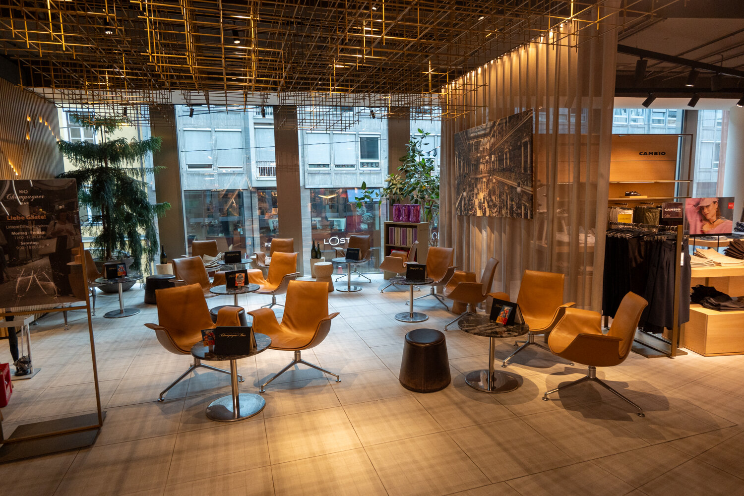 Gemütlicher Sitzbereich mit Ledersesseln, Holzdecken-Installation und großen Fensterfronten in der Champagner-Bar.