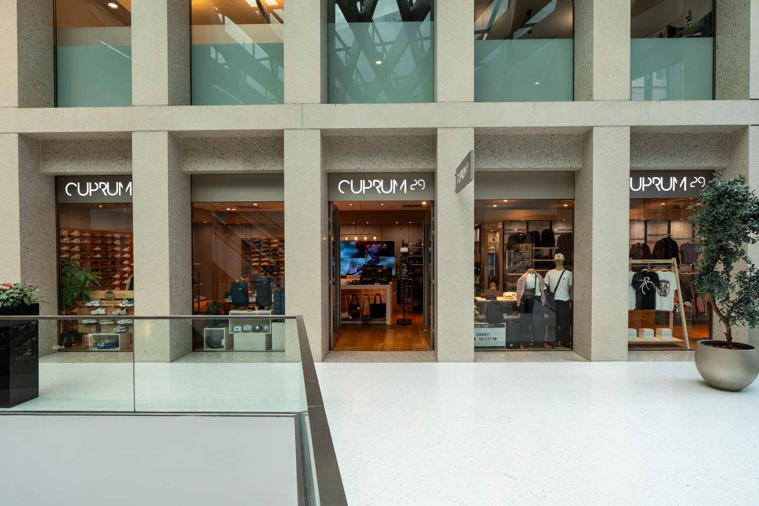 Außenansicht des Cuprum 29 Stores im Einkaufscenter mit großen Schaufenstern Einblick in die Schuh- und Bekleidungsabteilung.