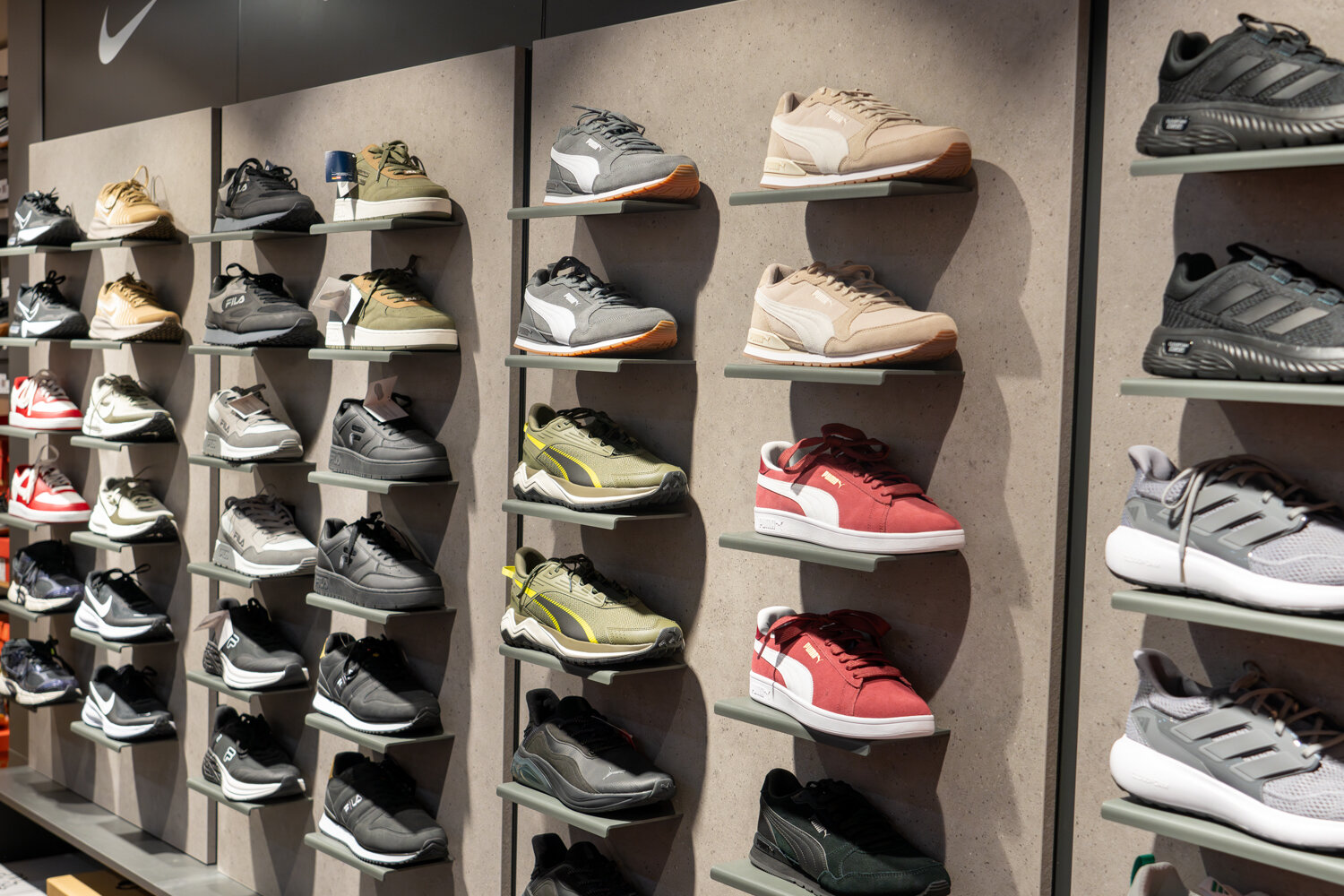 Moderne Wandpräsentation von Sportschuhen und Marken-Sneakern unter anderem von Puma, Fila und Nike bei Deichmann.