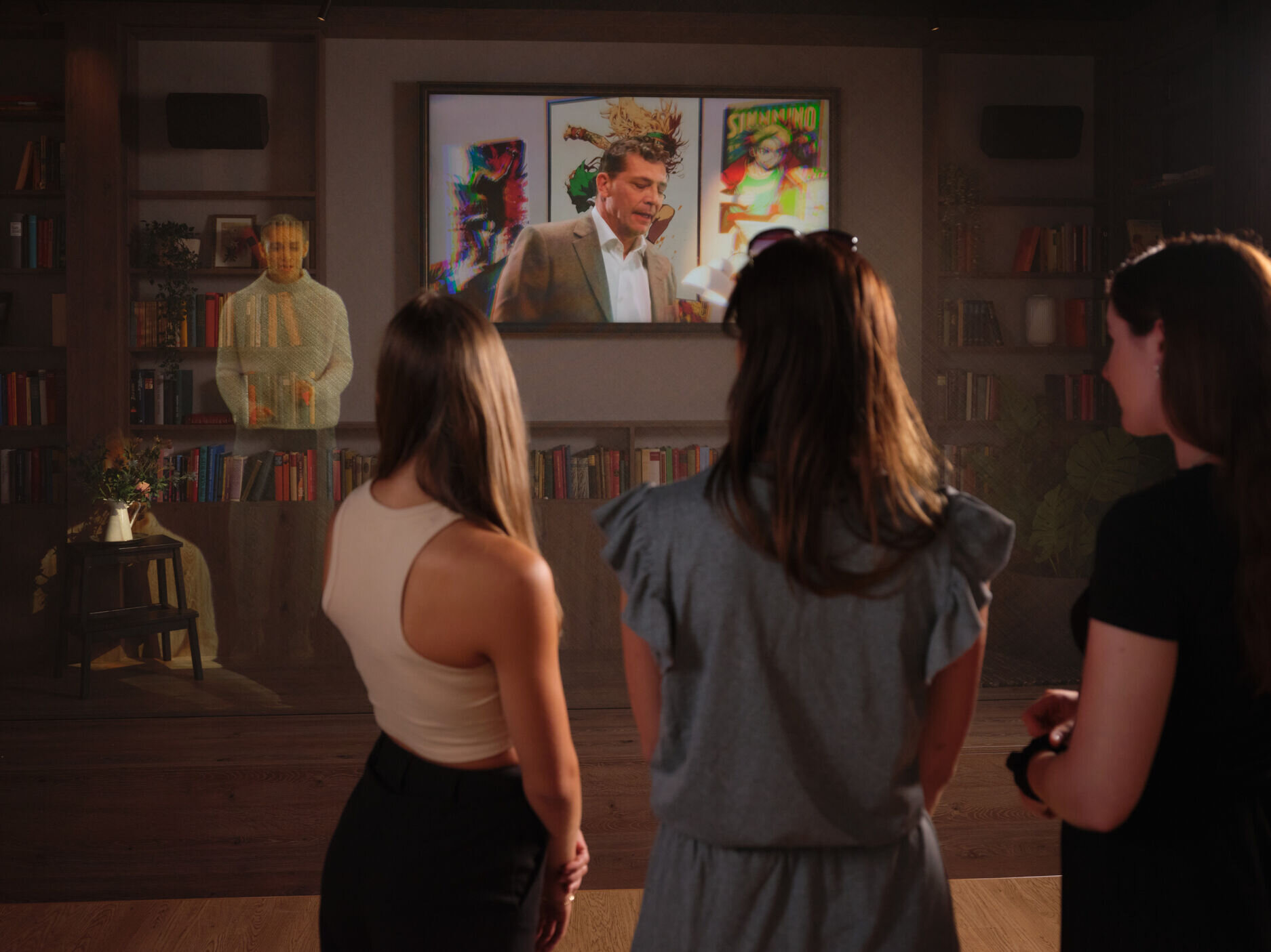 Drei Frauen betrachten eine digitale Hologramm-Präsentation auf einem Bildschirm und im Raum.