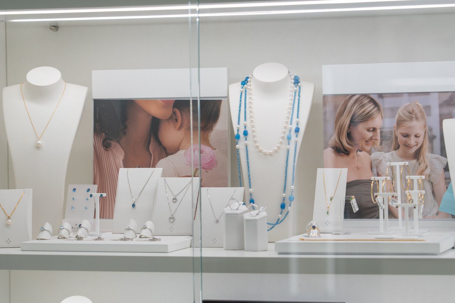 Schmuckpräsentation bei Juwelier Jurtschnitsch mit blauem Edelsteinschmuck, Silberketten, Ringen und Ohrhängern.