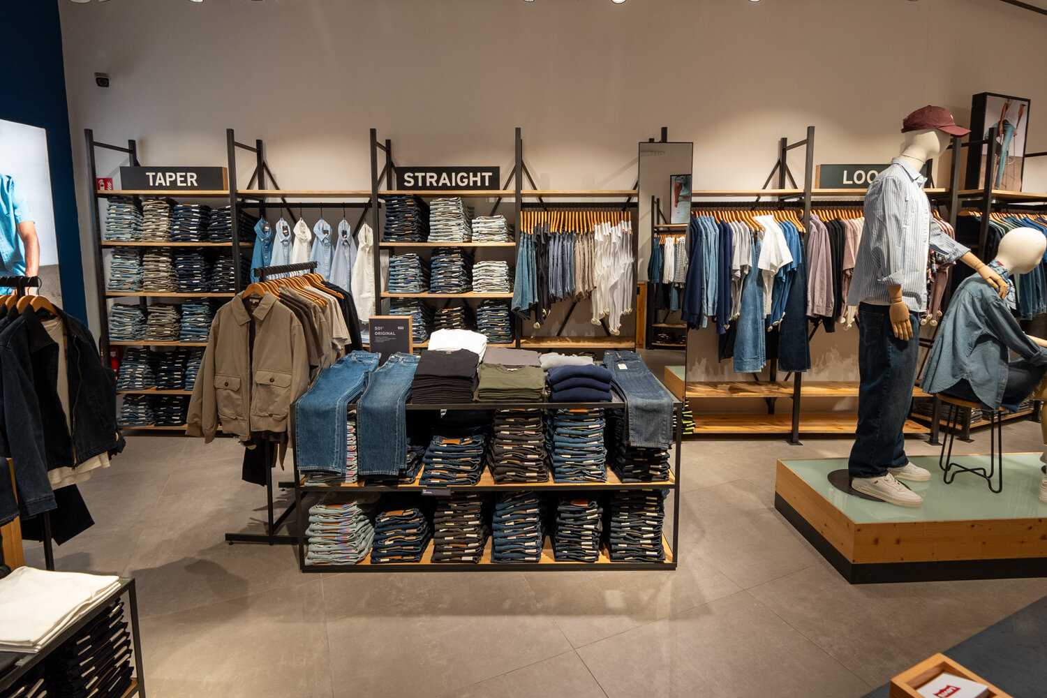 Verkaufsraum im Levi's Store mit Jeans-Wand und Schaufensterpuppen.
