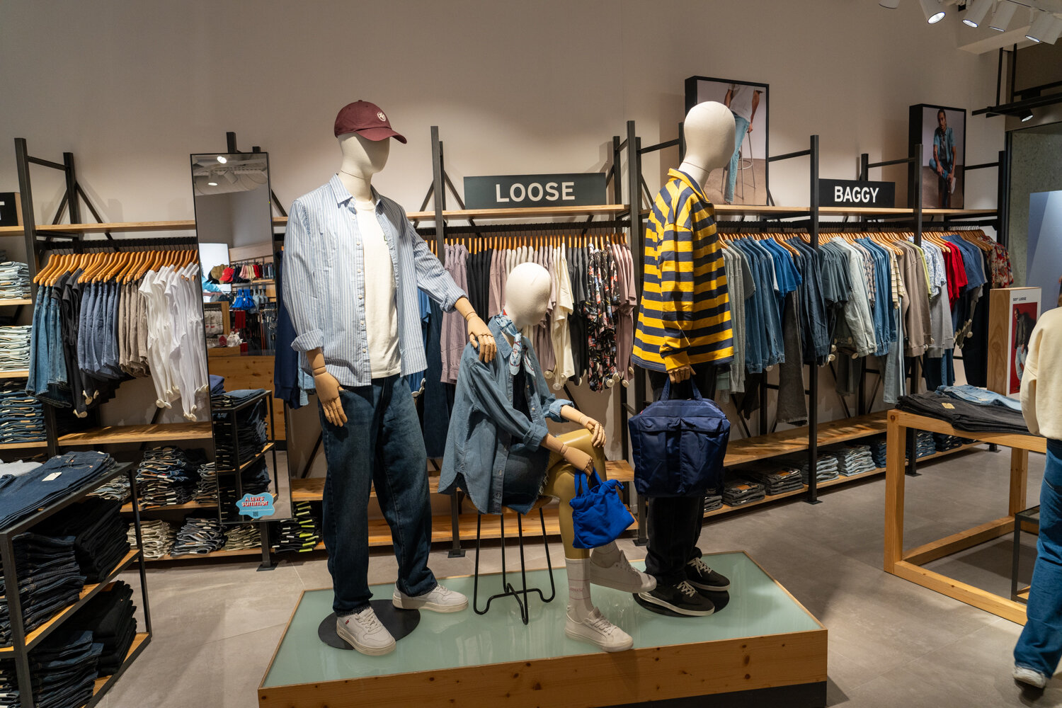 Schaufensterpuppen im Levi’s Store in lässigen Casual-Outfits vor Kleiderständern für Loose und Baggy Fits.