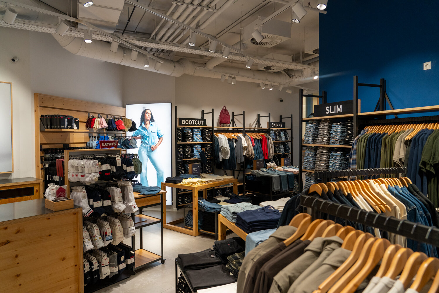 Übersicht der Verkaufsfläche im Levi’s Store mit verschiedenen Jeans-Passformen, Bekleidungsständern und Socken-Präsentation.
