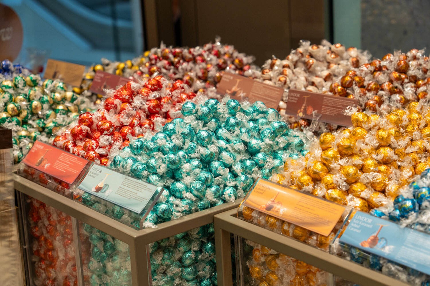 Nahaufnahme der Lindor-Kugel-Station bei Lindt mit Sorten wie Kokosnuss, Karamell und Salz-Karamell.