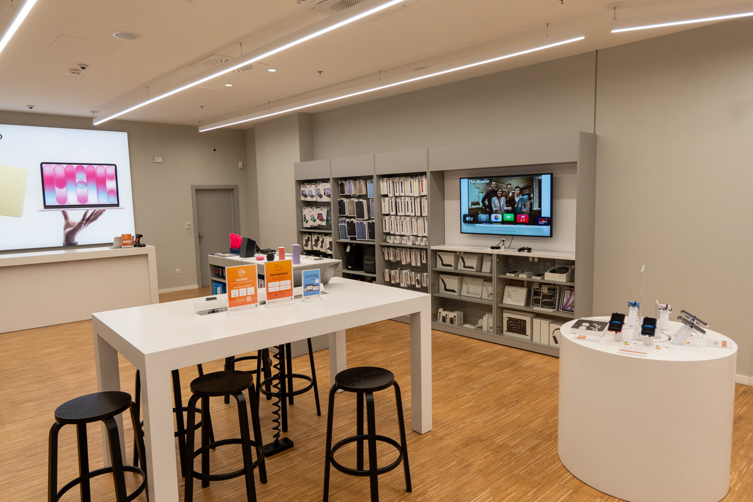 Beratungstisch mit Hockern und Apple Zubehörwand im McSHARK Store.