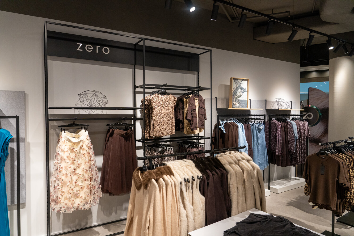 Verkaufsfläche im zero Store mit Wandregalen voller Kleider, Röcke, Strickjacken und Leopard-Prints.