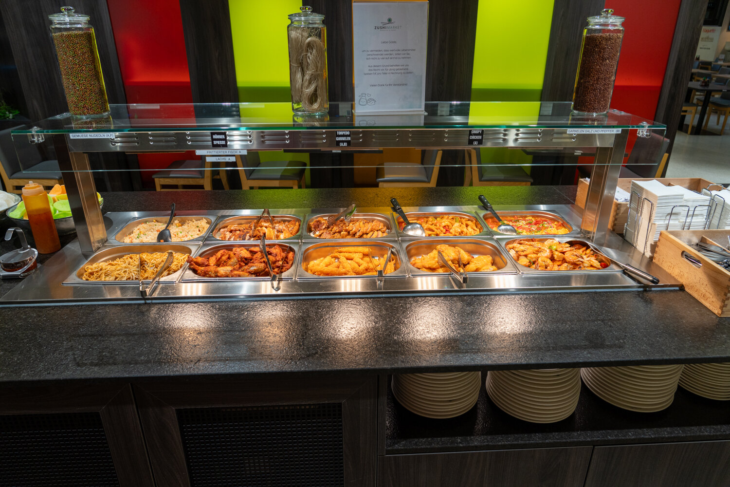 Warmhaltebuffet bei Zushi Market mit asiatischen Gerichten wie gebratenen Nudeln, Hähnchen, Frühlingsrollen und Garnelen.